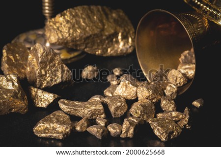 A golden ore scattered on the table close up background concept.