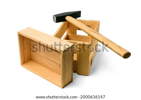 The hammer is on the wooden boxes. There are two boxes and hammer on white background. This is isolated view of hummer and boxes.