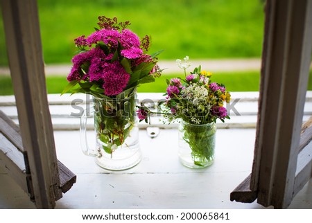 Two bouquets of flowers on the open window