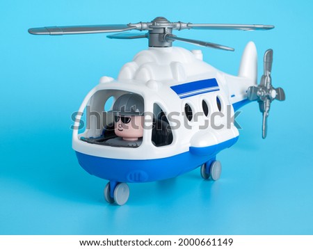 Plastic large helicopter model with movable propeller blades, children's toy, on a blue background