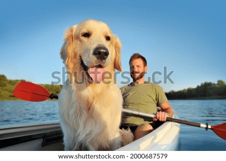 Close-up picture of a golden retriever in the kayak with his owner