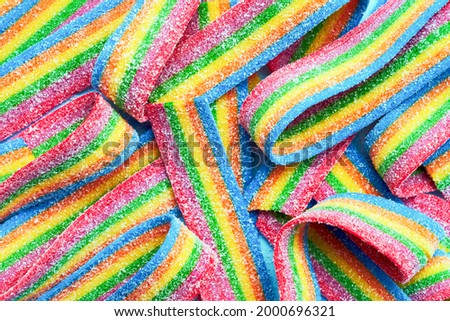 Colorful jelly candies in sugar sprinkles. Sour flavored rainbow candy background. Top view Royalty-Free Stock Photo #2000696321