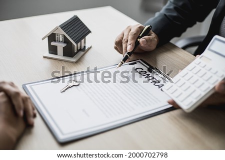 Employees use the calculator to calculate monthly rent for tenants and explain renting details and calculate monthly rent payments to tenants before signing the contract. Renting a house concept.