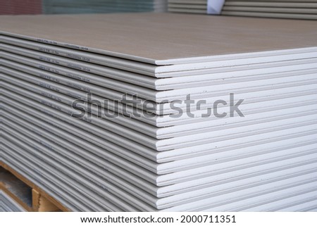 The stack of WHITE Standard Gypsum board panel. Plasterboard. Panel Type A designed for indoor walls, partitions and ceilings, construction site Royalty-Free Stock Photo #2000711351