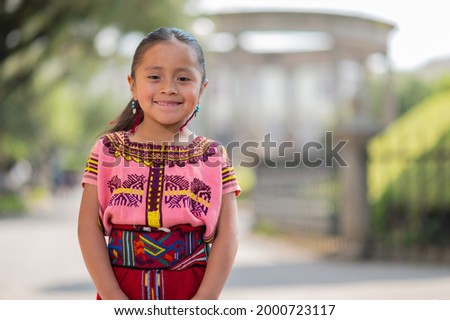 Portrait of a beautiful indigenous girl with a colorful dress from Quiche. Royalty-Free Stock Photo #2000723117