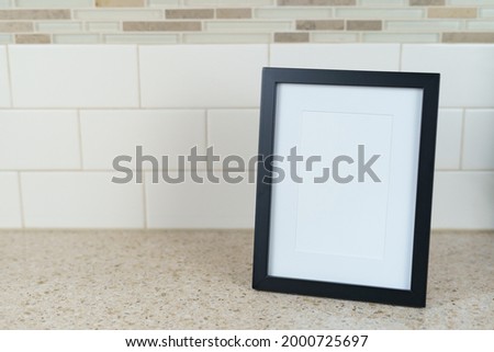 blank vertical picture frame on tile background