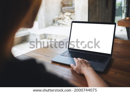 Mockup image of a woman using and touching on laptop touchpad with blank white desktop screen