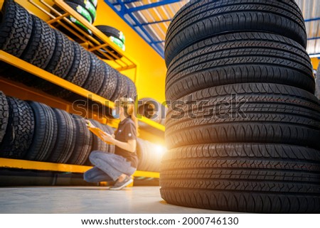 Asian female tire changer new tires in stock to be replaced at a service center or auto repair shop Tire depot for the automobile industry