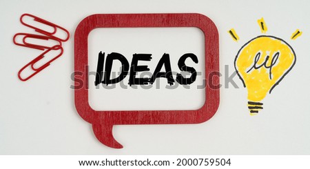 Idea and business concept. On paper, a drawing of a lamp, paper clips and a sign with the inscription - ideas