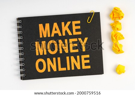 Business concept. On a white background lies a marker, an exclamation mark made of paper and a notebook with the inscription - MAKE MONEY ONLINE
