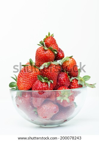 A cup of fresh strawberries on a white background
