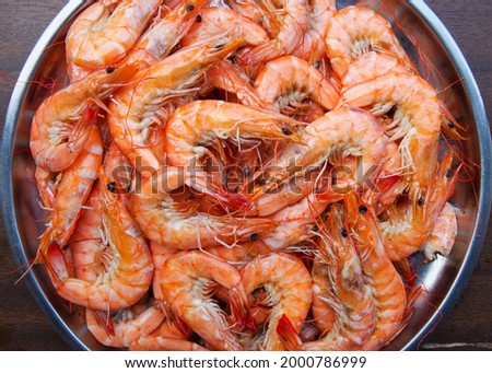 The above picture of shrimp or prawn That was made by steaming or boiling or baking, was placed in a large silver pan. The brown wooden floor looks delicious and ready to be eaten. Deliciously Happy