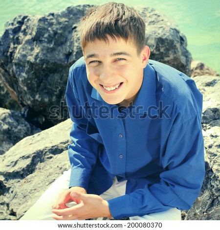 Toned photo of Happy Teenager sitting on the Stone outdoor