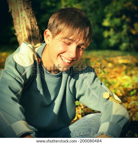 Toned photo of Happy Teenager laughing in the Autumn Park