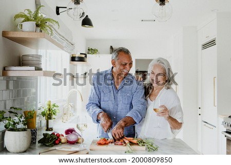 Elderly couple cooking in a kitchen Royalty-Free Stock Photo #2000809850