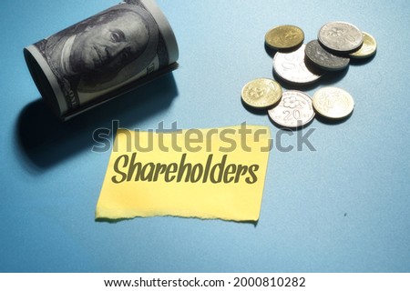 Top view image of money and stacked coins with Shareholders wording. Business concept