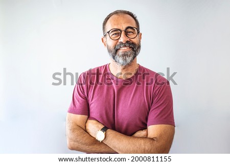 Portrait of mature businessman. Male executive is wearing T-shirt. Professional is smiling against gray background. Confident businessman with arms crossed. Mature mixed race man smiling Royalty-Free Stock Photo #2000811155