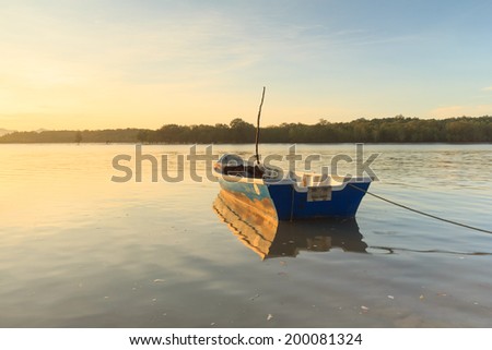 Boat at sunrise with reflection in Buntal Village