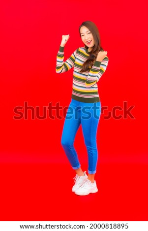 Portrait beautiful young asian woman smile with action on red isolated background