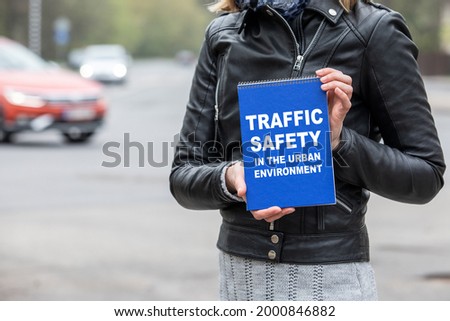 Traffic safety in the urban environment. Notebook in woman's hands.