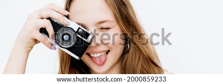 Playful woman taking a picture with a film camera