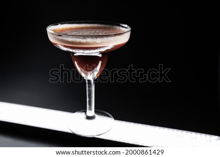 luxury espresso martini cocktail drink in elegant glass on black background