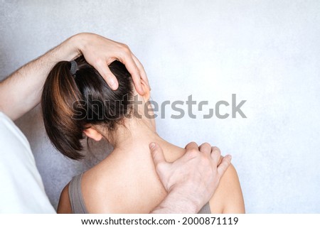 A woman having chiropractic neck adjustment. Osteopathy, kinesiology, bad posture correction Royalty-Free Stock Photo #2000871119