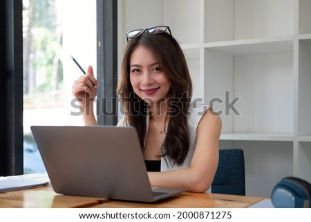 Young pretty asian businesswoman with laptop computer in the office