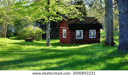 Adorable old red playhouse in spring Royalty-Free Stock Photo #2000892221