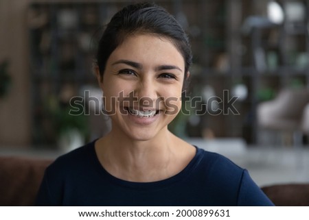 Headshot portrait of happy millennial woman of indian ethnicity make video call from home talk on gadget webcam on training webinar conference. Profile picture of teen ethnic female at social network