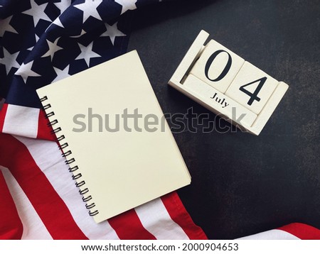 notebook with copy space for text, american flag and wooden calendar on black background, 4th of july, happy memorial day concept