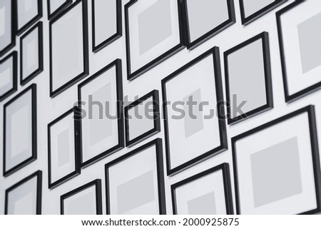 Various blank photo frames on white wall
