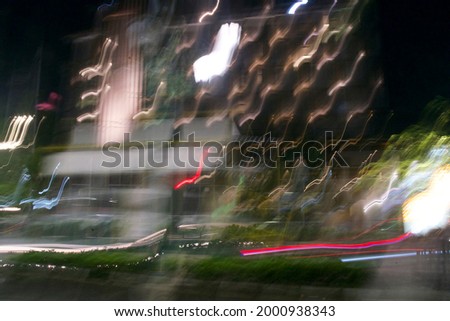 Slow shutter speed with blurred background of buildings and vehicles. Speed of lights at night