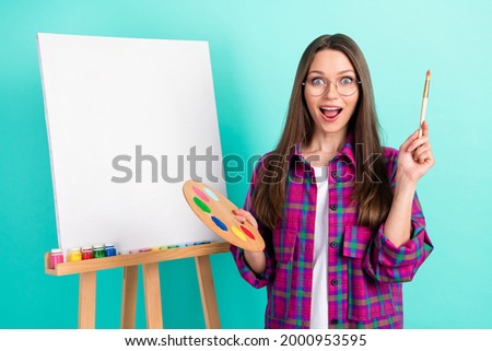 Portrait of attractive trendy amazed cheerful girl painting picture oil good idea isolated over bright teal green color background
