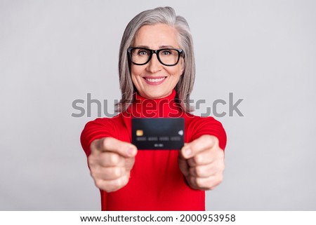 Photo of aged woman happy positive smile hold credit card bank customer isolated over grey color background