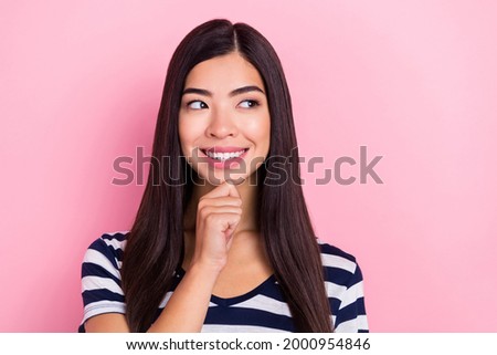 Photo of pretty thoughtful young woman wear striped outfit arm chin looking empty space smiling isolated pink color background