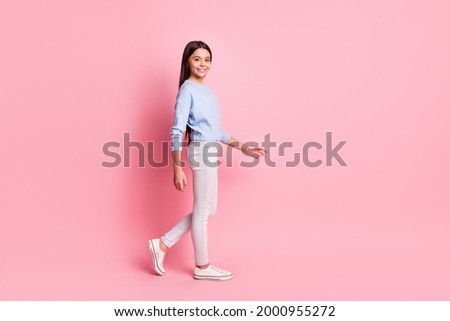 Full length body size profile side view of charming cheerful girl strolling step isolated over pink pastel color background