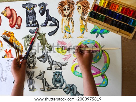 The animator draws with a pencil and draws characters from cartoons, comics or puppet shows. Getting ready to make a doll. The designer creates sketches. Comics, cartoons, puppet theater
