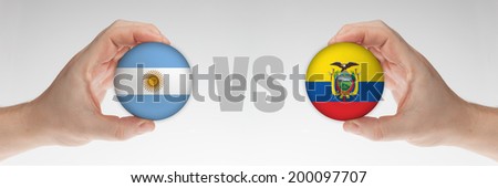 Man's hands holding styrofoam balls with Argentinian and Ecuador flag against the white background.