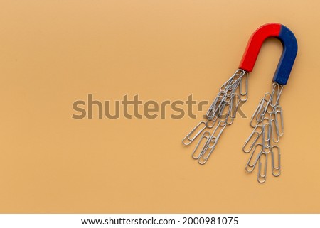 Horseshoe magnet collecting paper clips. Office supplies top view