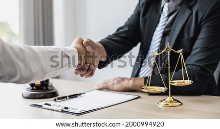Lawyer and client shake hands, after winning a lawsuit where a lawyer hired by a client in a fraud case and proceeding in a fair and correct manner, the client wins the case. Fraud litigation concept. Royalty-Free Stock Photo #2000994920