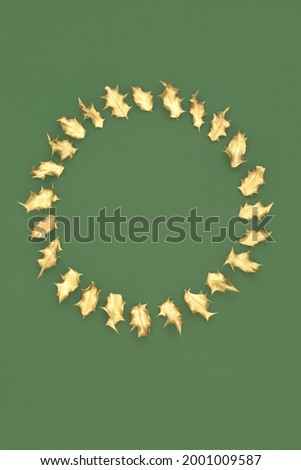 Christmas, winter and New Year wreath with gold holly leaves on green background. Festive minimal symbol for the holiday season. Top view, copy space.