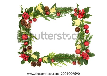  Creative abstract Christmas background with red bauble decorations, holly and winter greenery Xmas and New Year festive composition. On white, top view, copy space.