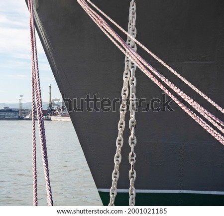 Closeup of black ship's board with boom chain and ropes