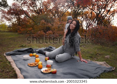 family outdoor at autumn golden time. Mother with kid girl drinking hot chocolate or tea outdoors at autumn season.