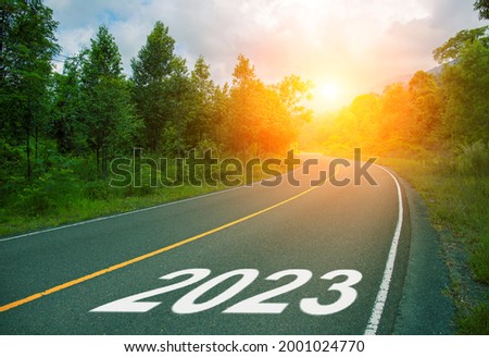 2023, concept photo of asphalt road. 2023 Year Calendar cover with summer forest and road. Optimistic landscape with sun dawn on road ahead. New Year banner template. Scenic road card with 2023 year