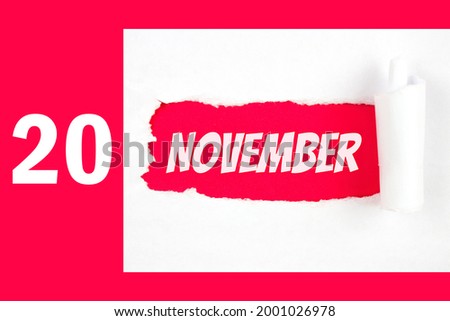 November 20th. Day 20 of month, Calendar date. Red Hole in the white paper with torn sides with calendar date. Autumn month, day of the year concept