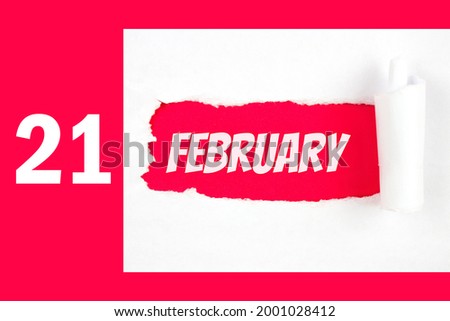 February 21st . Day 21 of month, Calendar date. Red Hole in the white paper with torn sides with calendar date. Winter month, day of the year concept