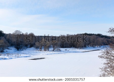 the surface of the river covered with ice and snow, frozen in the winter season