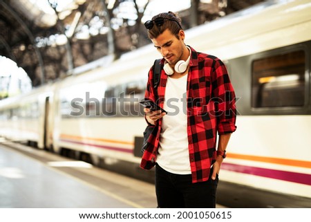 Happy young man waiting for the train. Smiling man waiting in a subway	 Royalty-Free Stock Photo #2001050615